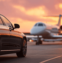 View of black luxury car with private white jet in the background