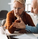 frustrated senior couple on laptop