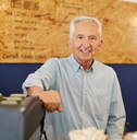 An old man working at a coffee shop
