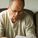 An old man looking at a bill