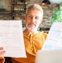 Man in his 50's looking at paperwork at home
