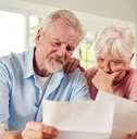 Concerned couple reviewing papers