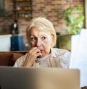 Older woman looking at papers worried face