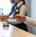 Receptionist hands a room key card to a hotel guest during check-in