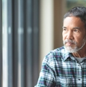 Mature man looking out window