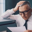 Finance man looking at document surprised and worried