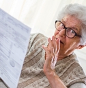 Retired senior woman looking at document worried