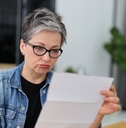 Confused Gen X retired woman reviewing a letter
