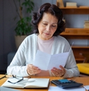 Older woman doing paperwork in her home office