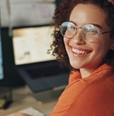 Woman wearing glasses smiling at the camera while working from home