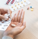 Close-Up Hands Holding Medication and Water Glass