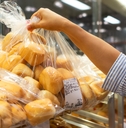 Costco Bakery shopper grabs a bag of bread rolls