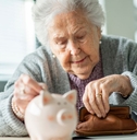 Elderly woman with a coin pouch and piggy bank