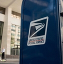 Closeup of a USPS mailbox in a downtown area