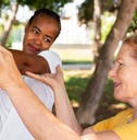 Older woman helping younger woman stretch