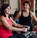 Two senior women working out at the gym