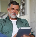 Man on the couch looking at tablet