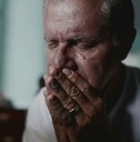 Portrait of older man with face in hands