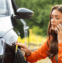 Woman looking at damage from accident