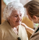 Health visitor talking to a senior woman during home visit