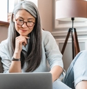 Older woman on couch with laptop