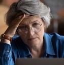 Stressed older woman on laptop