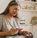 Happy senior woman making online payments of bill using laptop