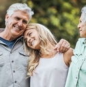 Senior couple embracing adult daughter