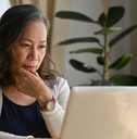 Mature woman on laptop in dining room