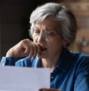 Concerned older woman reviewing letter
