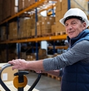 Older male warehouse worker smiling