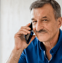 Man in his 60s on cell phone at home
