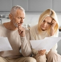 Mature couple on couch reviewing papers