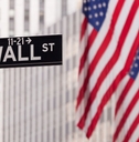 Wall Street road sign with American flags in background