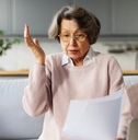 Senior woman surprised looking at paperwork