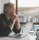 Pensive looking mature man with laptop