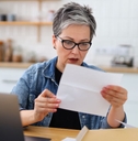 Shocked mature woman holding letter