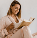 Woman drinking coffee in luxurious bedroom