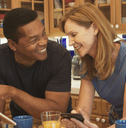 Couple in their 50s looking at tablet in kitchen