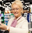Senior paying at self-checkout of grocery store