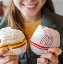 Woman smiling and holding two burgers from McDonalds