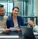 Young couple sitting with financial advisor at bank
