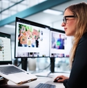 Woman reading articles on several computer screens