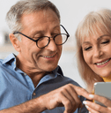 Older couple checking retirement accounts on phone