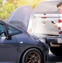 Man examining damage after car accident