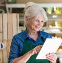 shop assistant with digital tablet in small grocery store