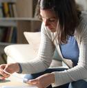 woman checking receipts at home at night