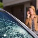 Woman Phoning For Help After Car Windshield Has Broken 