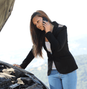 person looking at broken down car