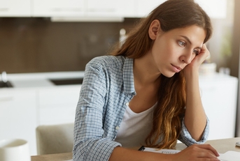 Stressed woman looking at bills